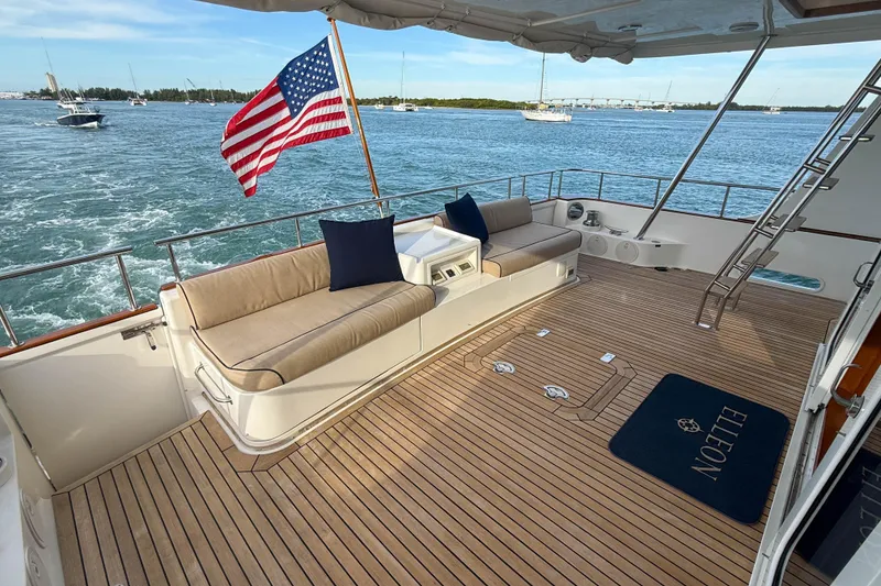 Slide: The Image of 2003 Grand Banks 64 Aleutian RP yacht deck with seating, American flag, and ocean view. - 6