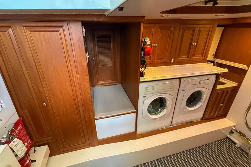 Slide: The Image of Laundry area in 2003 Grand Banks 64 Aleutian RP yacht with washer, dryer, and wooden cabinetry. - 75