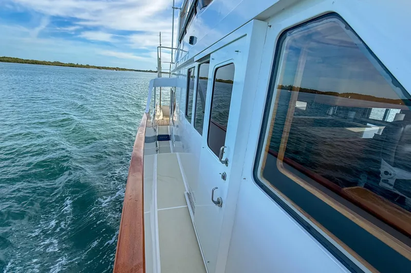 Slide: The Image of 2003 Grand Banks 64 Aleutian RP yacht cruising on calm waters under a blue sky. - 72