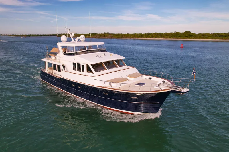 Slide: The Image of Grand Banks 64 Aleutian RP 2003 yacht cruising on calm waters under a clear sky. - 1