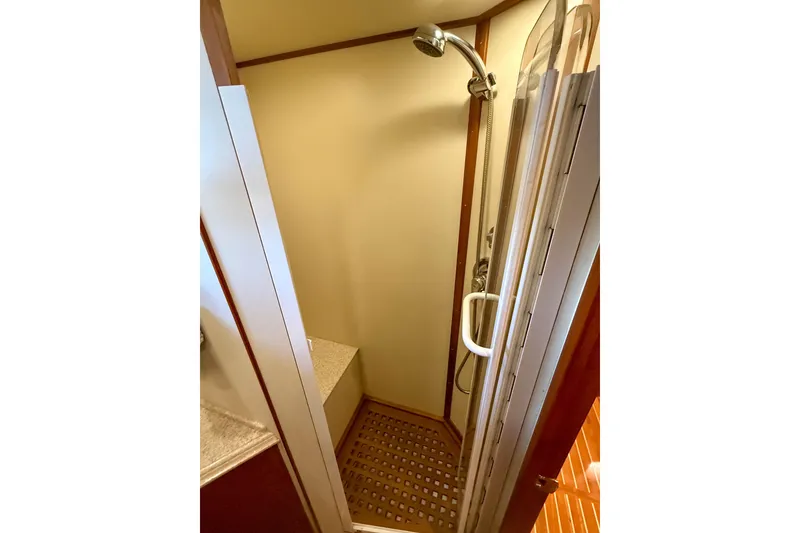 Slide: The Image of Shower area in 2003 Grand Banks 64 Aleutian RP yacht, featuring wooden flooring and modern fixtures. - 62