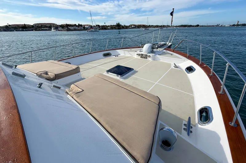 Slide: The Image of Luxurious 2003 Grand Banks 64 Aleutian RP yacht deck with sun loungers on calm water. - 68