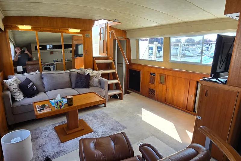 Slide: The Image of Interior of 1984 Bertram 42 Flybridge Motor Yacht with cozy seating and wooden accents. - 18