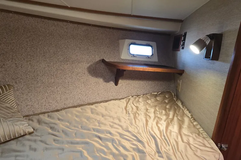 Slide: The Image of Cozy cabin interior of 1984 Bertram 42 Flybridge Motor Yacht with bed and porthole. - 27