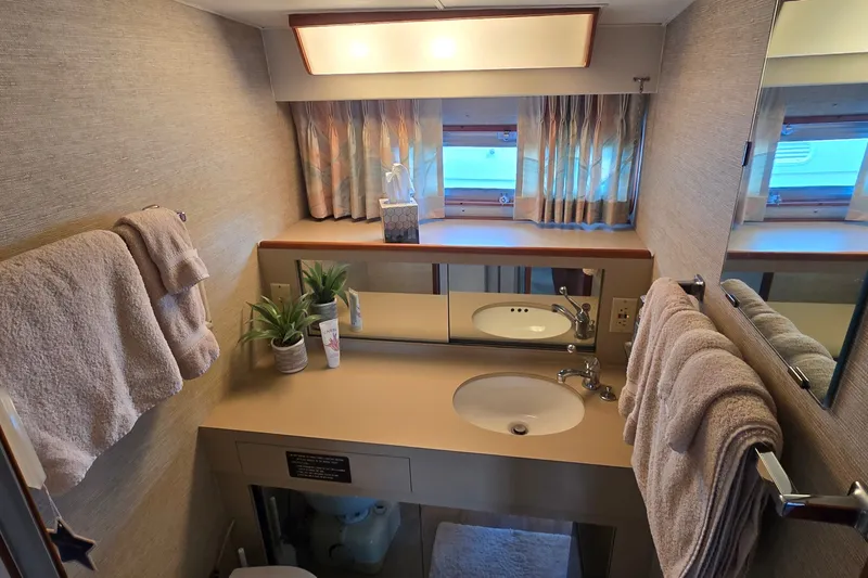 Slide: The Image of Bathroom interior of 1984 Bertram 42 Flybridge Motor Yacht with sink, mirror, and towels. - 39