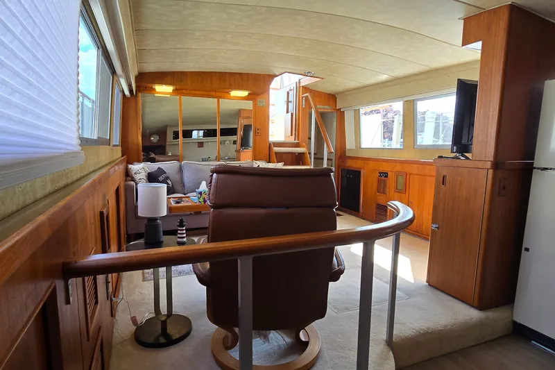 Slide: The Image of Interior of a 1984 Bertram 42 Flybridge Motor Yacht with cozy seating and wooden accents. - 32