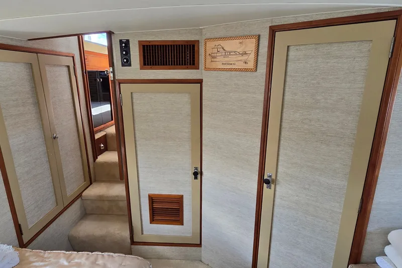 Slide: The Image of Interior of 1984 Bertram 42 Flybridge Motor Yacht with beige walls and wooden accents. - 36