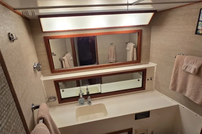 Slide: The Image of Bathroom interior of 1984 Bertram 42 Flybridge Motor Yacht with mirror and towels. - 24