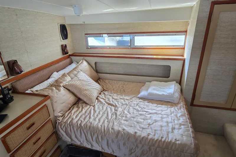 Slide: The Image of Cozy bedroom interior of 1984 Bertram 42 Flybridge Motor Yacht with elegant bedding. - 35
