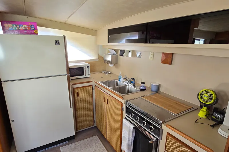 Slide: The Image of Compact kitchen in a 1984 Bertram 42 Flybridge Motor Yacht with appliances and storage. - 19