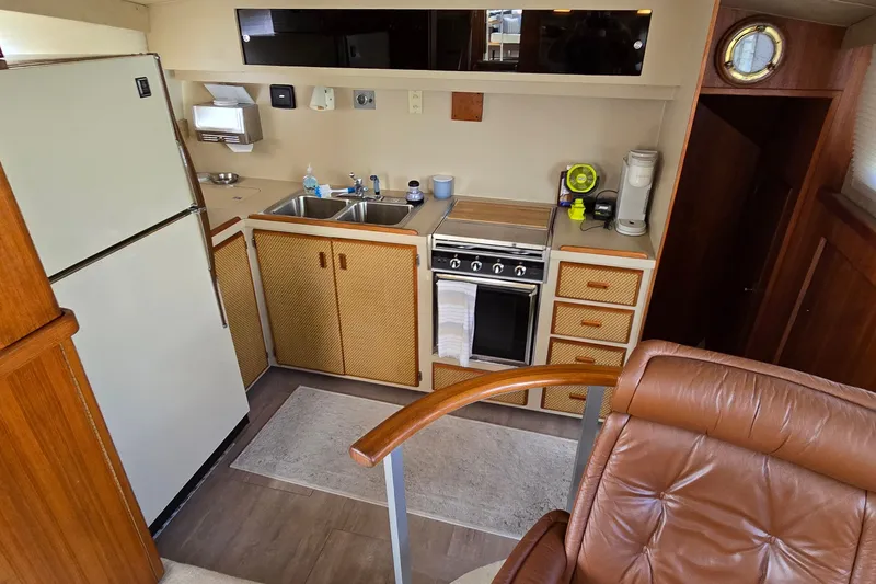 Slide: The Image of 1984 Bertram 42 Flybridge Motor Yacht kitchen with stove, sink, and refrigerator. - 21