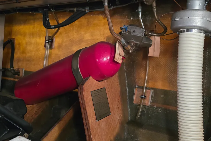 Slide: The Image of Engine room of 1984 Bertram 42 Flybridge Motor Yacht with red cylinder and mechanical components. - 55