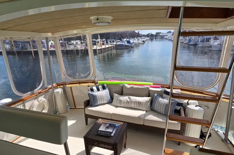 Slide: The Image of 1984 Bertram 42 Flybridge Motor Yacht interior with cozy seating and waterfront view. - 13
