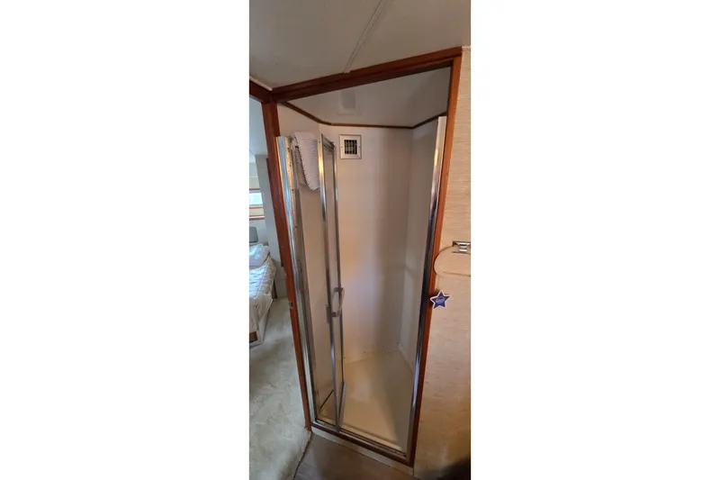 Slide: The Image of Shower area in 1984 Bertram 42 Flybridge Motor Yacht, featuring a glass door and wooden trim. - 38