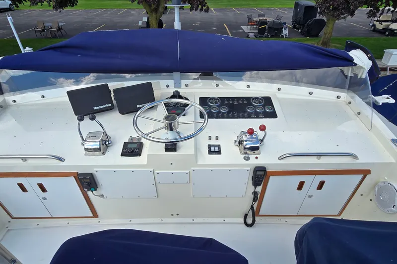 Slide: The Image of 1984 Bertram 42 Flybridge Motor Yacht helm with Raymarine electronics and classic steering wheel. - 14