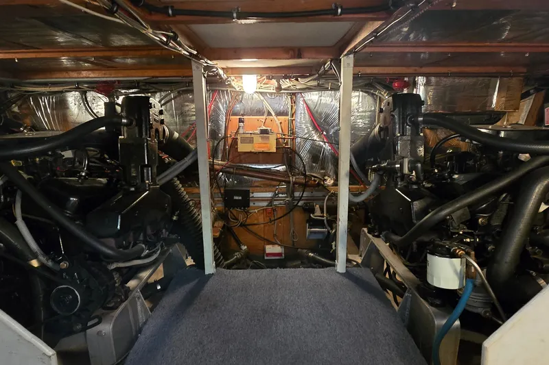 Slide: The Image of Engine room of a 1984 Bertram 42 Flybridge Motor Yacht, showcasing dual engines and wiring. - 54