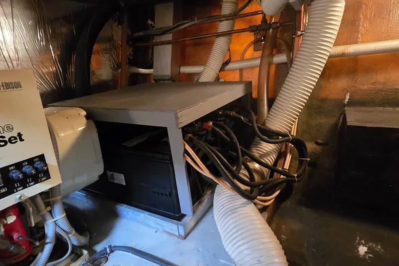Slide: The Image of Engine room of a 1984 Bertram 42 Flybridge Motor Yacht with visible wiring and equipment. - 48