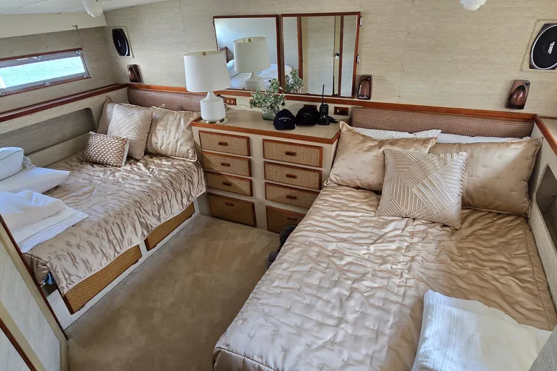 Slide: The Image of Luxurious 1984 Bertram 42 Flybridge Motor Yacht cabin with twin beds and elegant decor. - 34