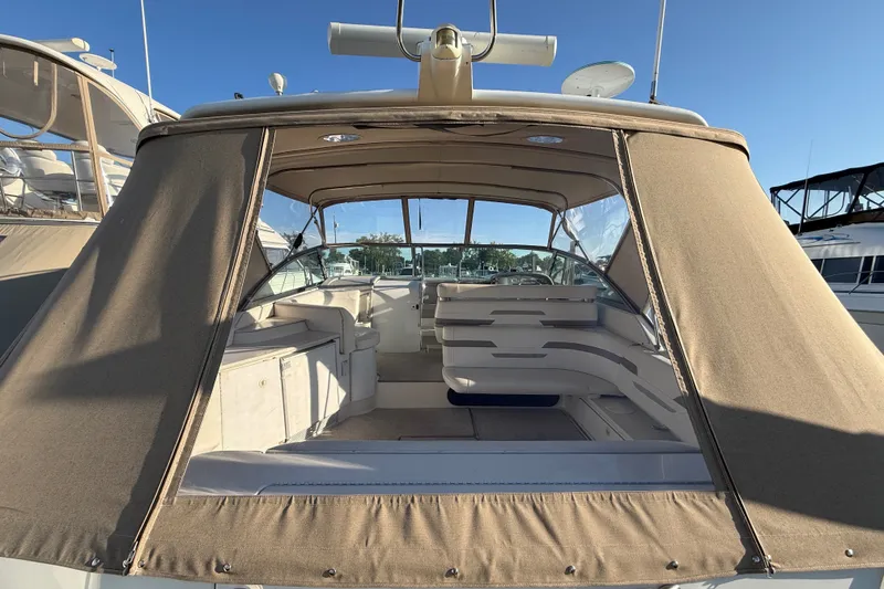 Slide: The Image of 2000 Formula 41 Performance Cruiser with beige canopy, docked under clear blue sky. - 8