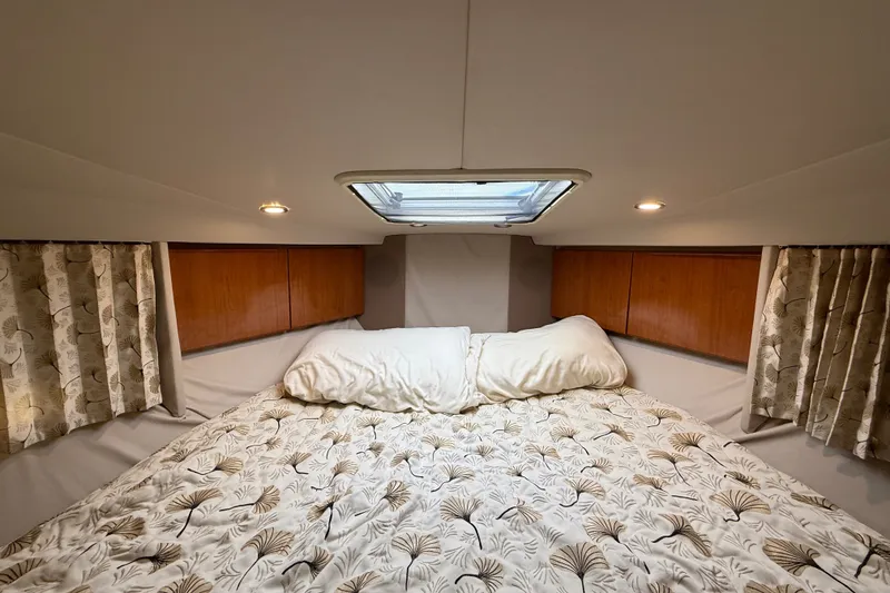 Slide: The Image of Cozy cabin interior of 2000 Formula 41 Performance Cruiser with patterned bedding and wooden accents. - 50