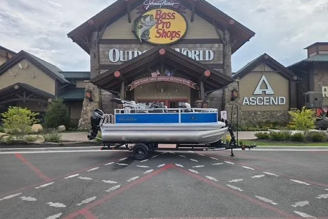 The Image of 2027 Sun Tracker Bass Buggy 16 XL Select pontoon boat outside Bass Pro Shops. - 0