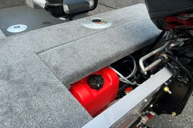 Slide: The Image of 2027 Tracker Super Guide V-16 SC boat interior with red fuel tank and gray carpet. - 14