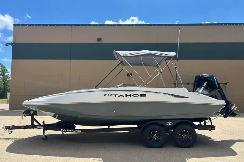 Slide: The Image of 2027 Tahoe 2150 boat on trailer, parked outdoors, featuring a sleek design and canopy. - 14