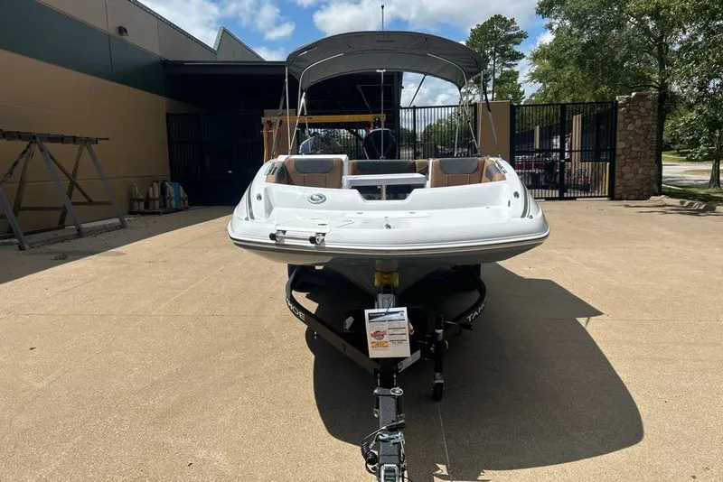 Slide: The Image of 2027 Tahoe 2150 boat on trailer, parked outdoors under a clear sky. - 11