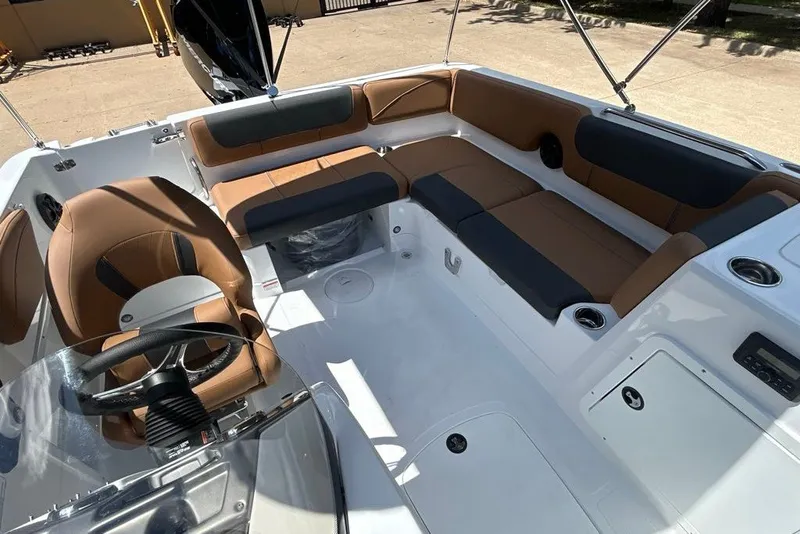 Slide: The Image of 2027 Tahoe 2150 boat interior with brown and black seating, steering wheel, and cup holders. - 8