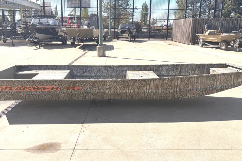 The Image of 2027 Tracker Grizzly 15 Jon boat with camouflage design on display outdoors. - 0