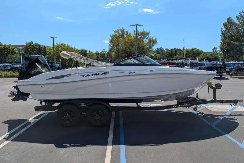 Slide: The Image of 2027 Tahoe 210 S boat on trailer in parking lot under clear sky. - 2