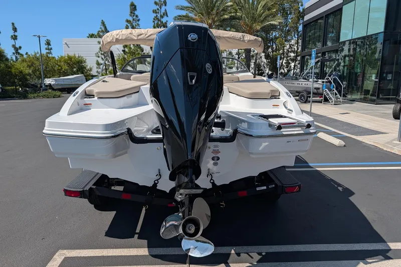 Slide: The Image of 2027 Tahoe 210 S boat with powerful outboard motor in a sunny parking lot. - 5
