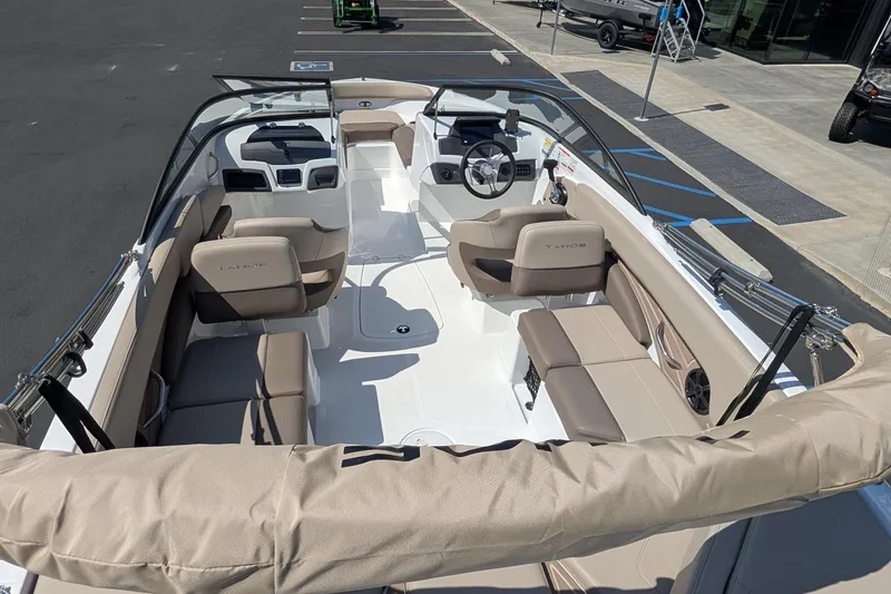 Slide: The Image of 2027 Tahoe 210 S boat interior with beige seating and modern dashboard. - 11