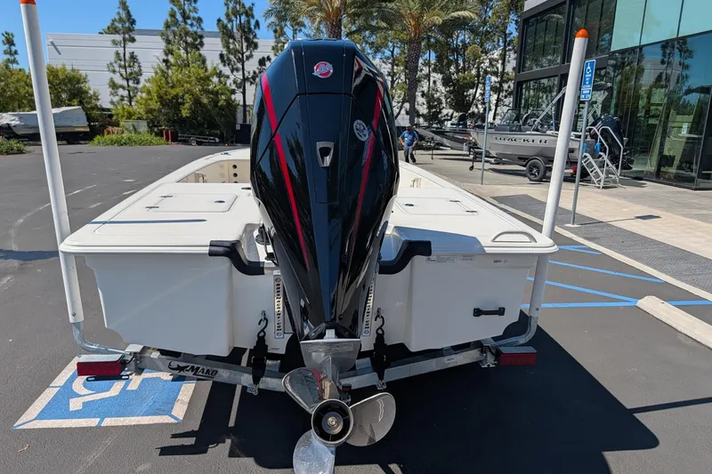 Slide: The Image of 2026 Mako 18 Pro Skiff boat with outboard motor in a parking lot. - 5