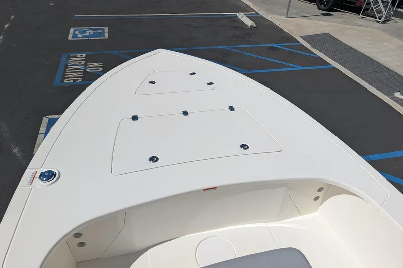 Slide: The Image of 2026 Mako 18 Pro Skiff boat parked in a lot with accessible parking spaces. - 9
