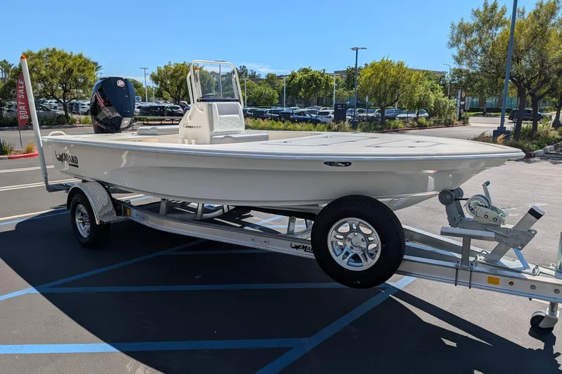 The Image of 2026 Mako 18 Pro Skiff boat on trailer in parking lot, sunny day. - 0