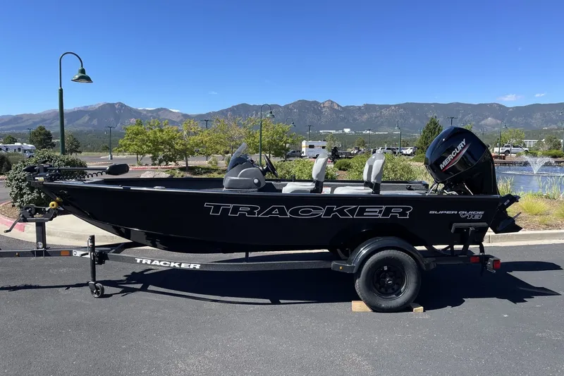 The Image of 2027 Tracker Super Guide V-16 SC boat on trailer, scenic mountain backdrop. - 0