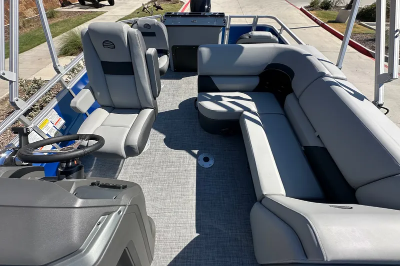 Slide: The Image of 2027 Sun Tracker SportFish 20 DLX pontoon boat interior with gray seating and steering console. - 22