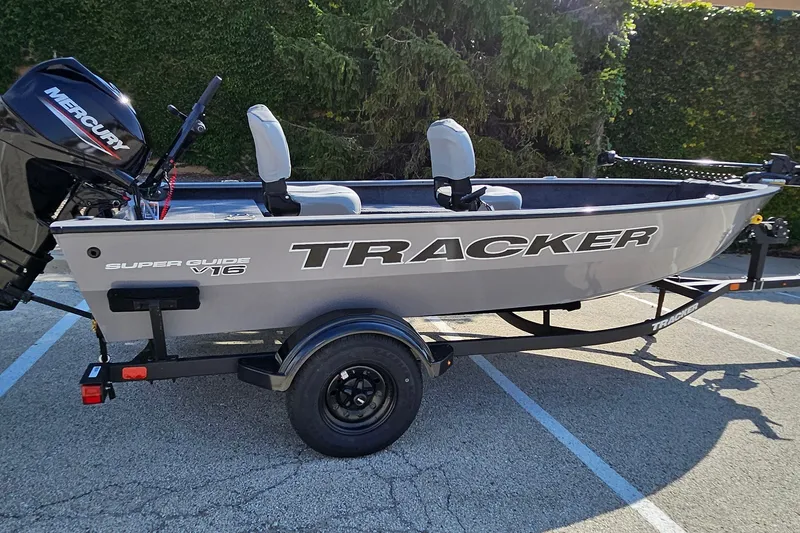 The Image of 2027 Tracker Super Guide V-16 T fishing boat on trailer, featuring Mercury outboard motor. - 0