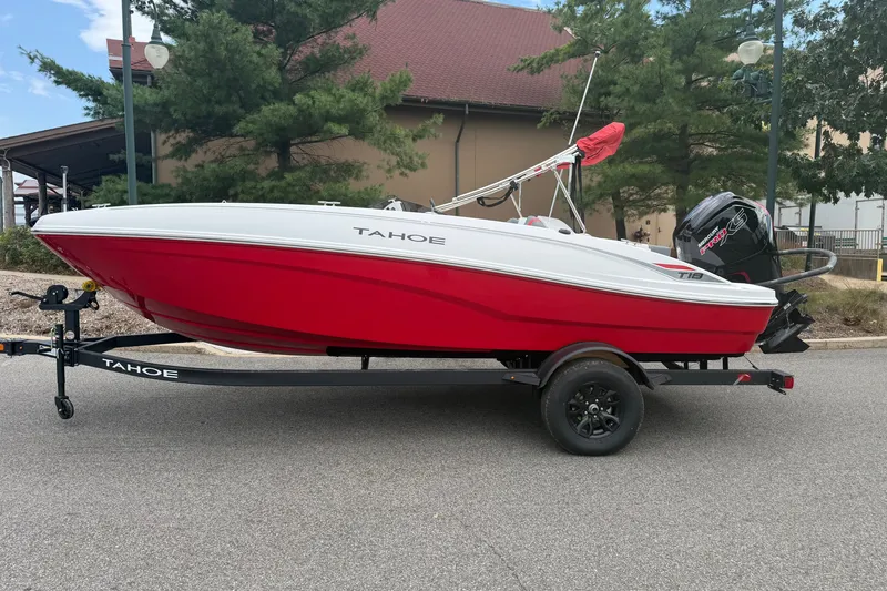 Slide: The Image of 2027 Tahoe T18 boat in red and white on a trailer, parked outdoors. - 1