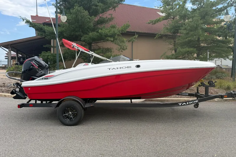Slide: The Image of 2027 Tahoe T18 boat in red and white on a trailer, parked outdoors. - 2