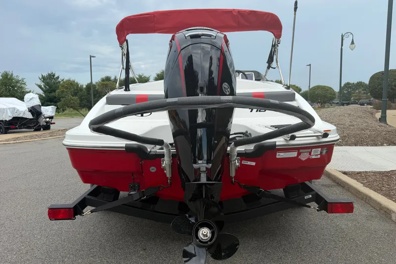 Slide: The Image of 2027 Tahoe T18 boat with outboard motor, red and white design, parked on a trailer. - 3