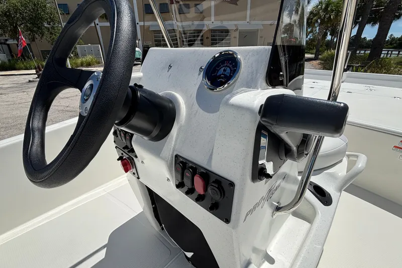 Slide: The Image of 2027 Mako Pro Skiff 17 CC boat console with steering wheel and controls. - 14