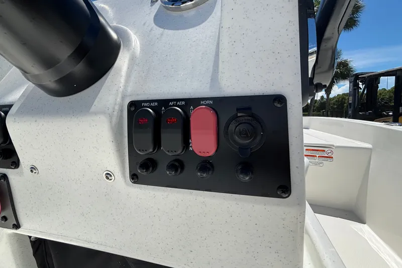 Slide: The Image of Control panel of 2027 Mako Pro Skiff 17 CC boat with switches and 12V outlet. - 12