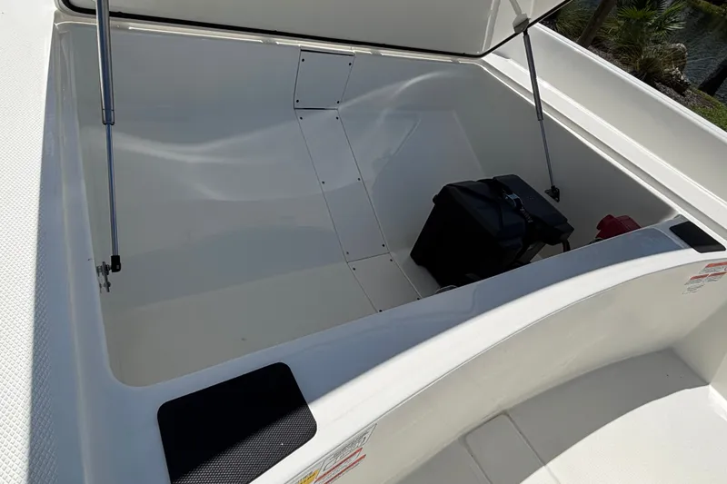 Slide: The Image of Open storage compartment of 2027 Mako Pro Skiff 17 CC boat with gear inside. - 7