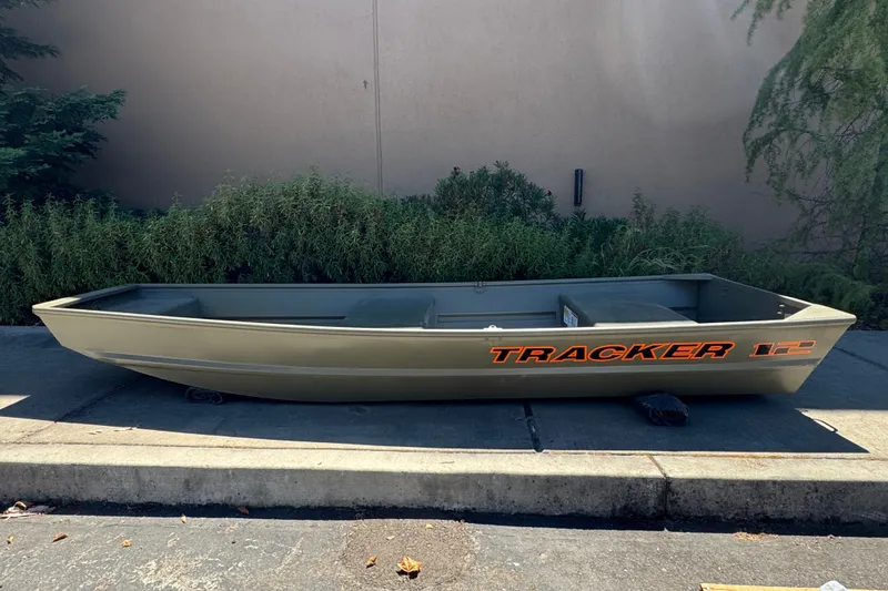 The Image of 2027 Tracker Grizzly 12 Jon boat on pavement, green exterior, side view. - 0