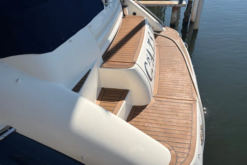Slide: The Image of 1997 Sunseeker Camargue 51 yacht with teak deck, docked by calm water. - 5