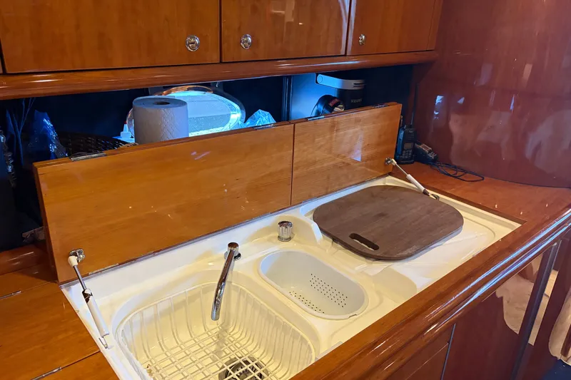 Slide: The Image of Kitchen area of 1997 Sunseeker Camargue 51 yacht with wooden cabinetry and sink. - 34