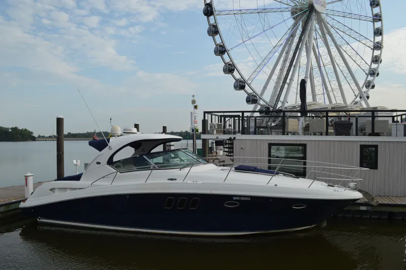 The Image of 2007 Sea Ray 38 Sundancer yacht docked near a Ferris wheel on a sunny day. - 0