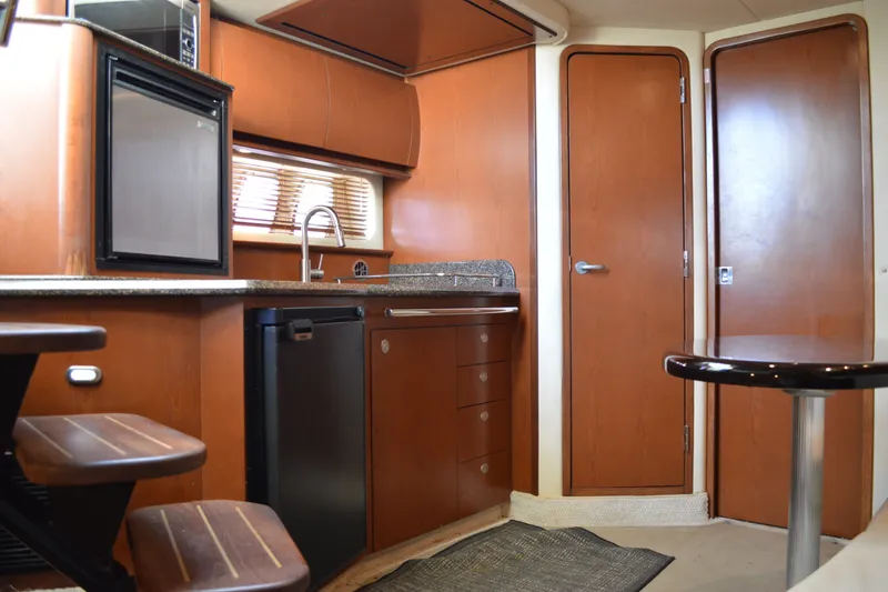 Slide: The Image of Interior of 2007 Sea Ray 38 Sundancer yacht with kitchenette and wooden cabinetry. - 21